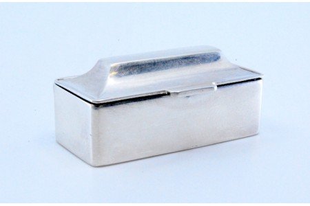 Caixa de comprimidos em prata lisa alteada e de forma retangular com tampa basculante.